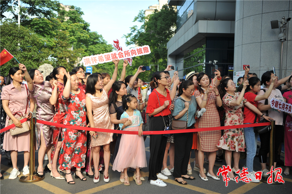 6月7日，送考家長拿著標(biāo)語牌為考生加油鼓勁。陳歡 攝.jpg