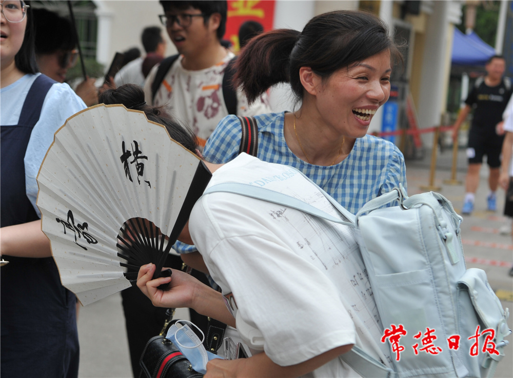 6月9日，在常德市一中考點，中午下考后，一名考生拿著一把寫著“豪橫”兩字的折扇，信心滿滿地走出考場，被前來迎考的媽媽一把抱住，激動之情溢于言表。本報記者 陳歡 攝.jpg